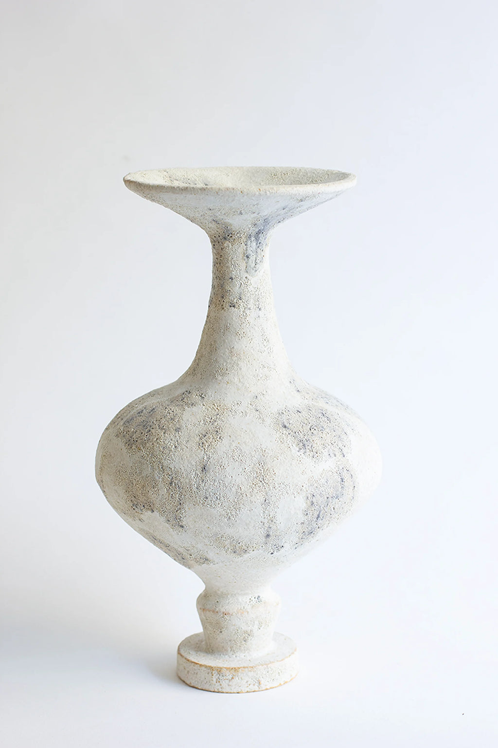 Canoa Lab Arq 002 Cárabo Vase, an artisanal handcrafted ceramic vase in off-white and cream tones with a highly textured, porous, and raw volcanic finish,.