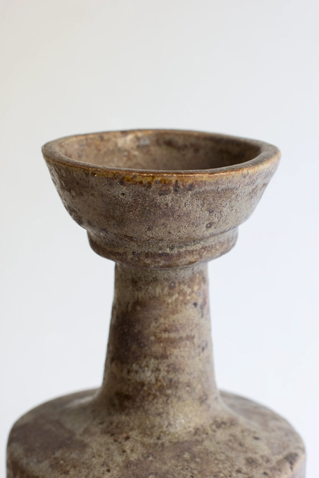 Canoa Lab Arq 003 Búfalo Vase, a close-up of the elegant ceramic vase's top opening, showcasing its textured dark brown and beige finish with subtle variations, displayed on a clean white background.