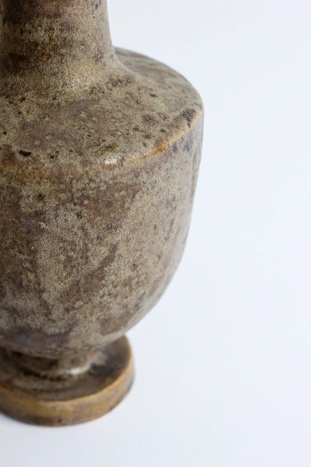 Canoa Lab Arq 003 Búfalo Vase, a close-up side view of the elegant ceramic vase's body, highlighting its textured dark brown and beige finish with unique patterns and a classic design, displayed on a clean white background.