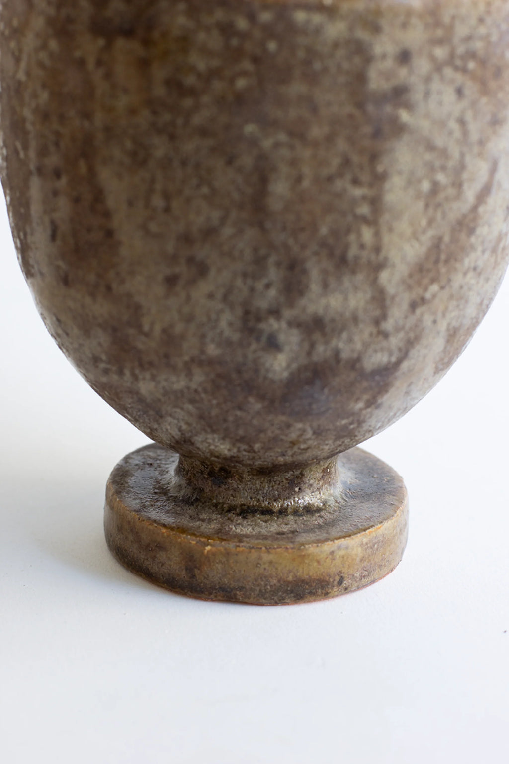 Canoa Lab Arq 003 Búfalo Vase, a rustic, earthy brown ceramic vase with a wide, rounded body and a sturdy, circular base, featuring a textured, mottled glaze, displayed on a clean white background.
