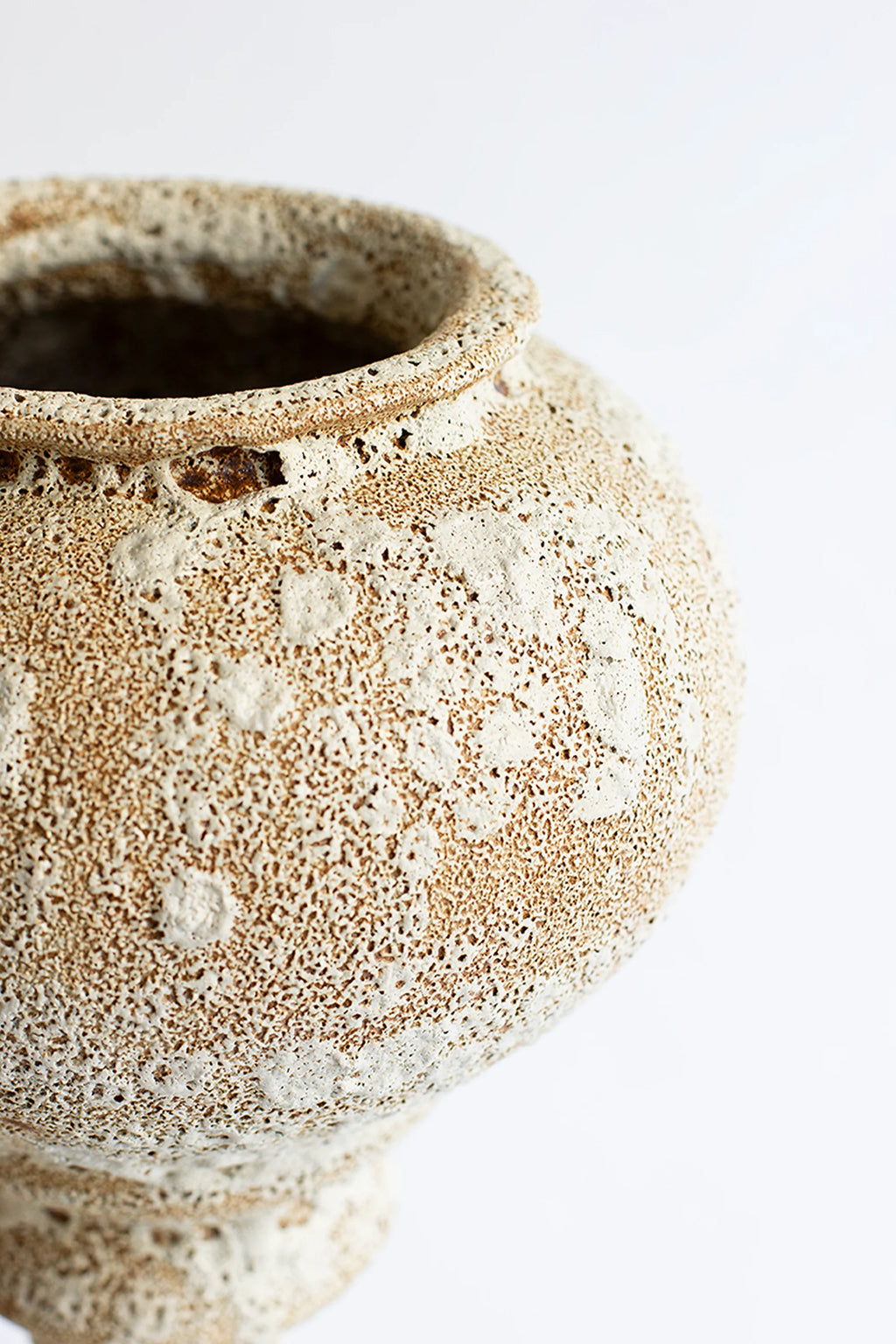 Canoa Lab Arq 012 Vase, a handcrafted ceramic vase with a distinctive porous, volcanic texture in warm cream and earthy brown tones, featuring a classic urn silhouette with a flared rim. This organic modern stoneware vase is perfect for rustic shelf styling, Japandi interiors, or as a unique living room accent.