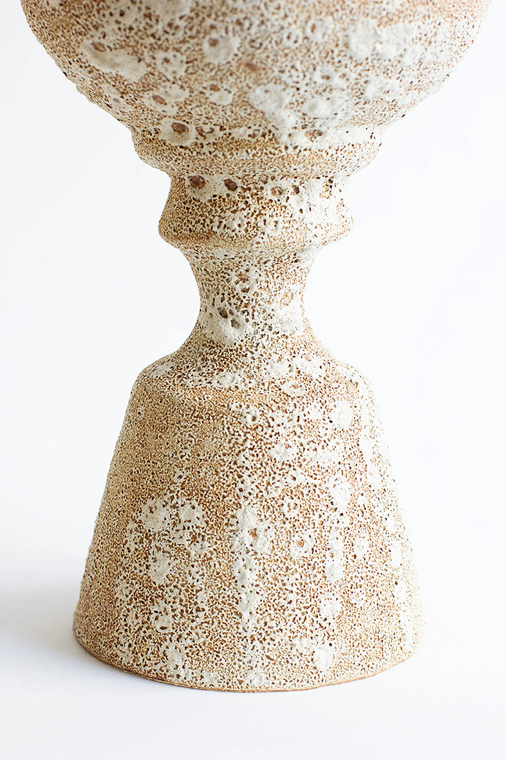Canoa Lab Arq 012 Vase, a full view of the elegant, hourglass-shaped ceramic vase with a textured, porous beige and white finish, featuring a wide base and a slender neck, displayed on a white background.