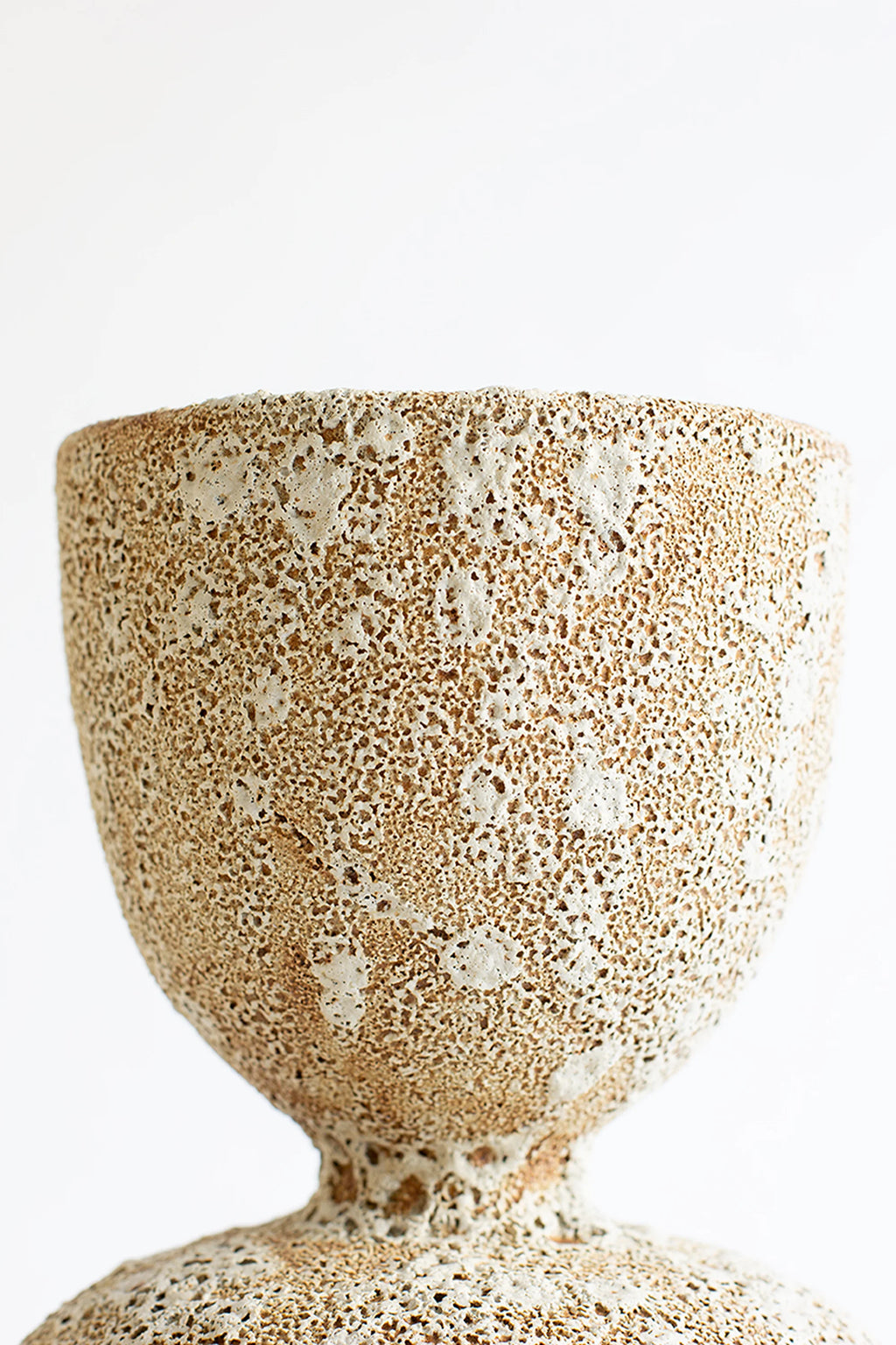 Canoa Lab Arq 013 Vase, a close-up of the upper, cup-shaped section of the modern ceramic vase. The textured surface features prominent white speckles over a warm, sandy beige, highlighting its handcrafted, organic design. Displayed on a clean white background.