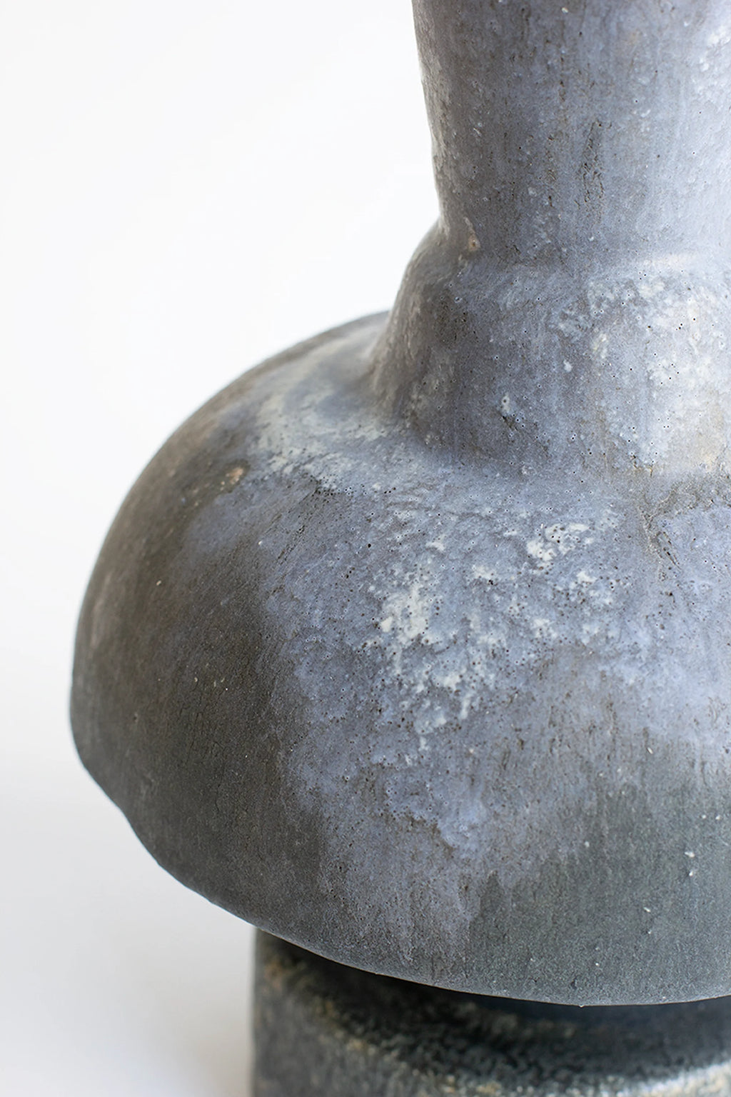 Canoa Lab Arq 014 Vase, a handcrafted ceramic vase featuring a rich dark charcoal and matte grey finish with a distinctive porous, volcanic texture and an organic, sculptural silhouette.
