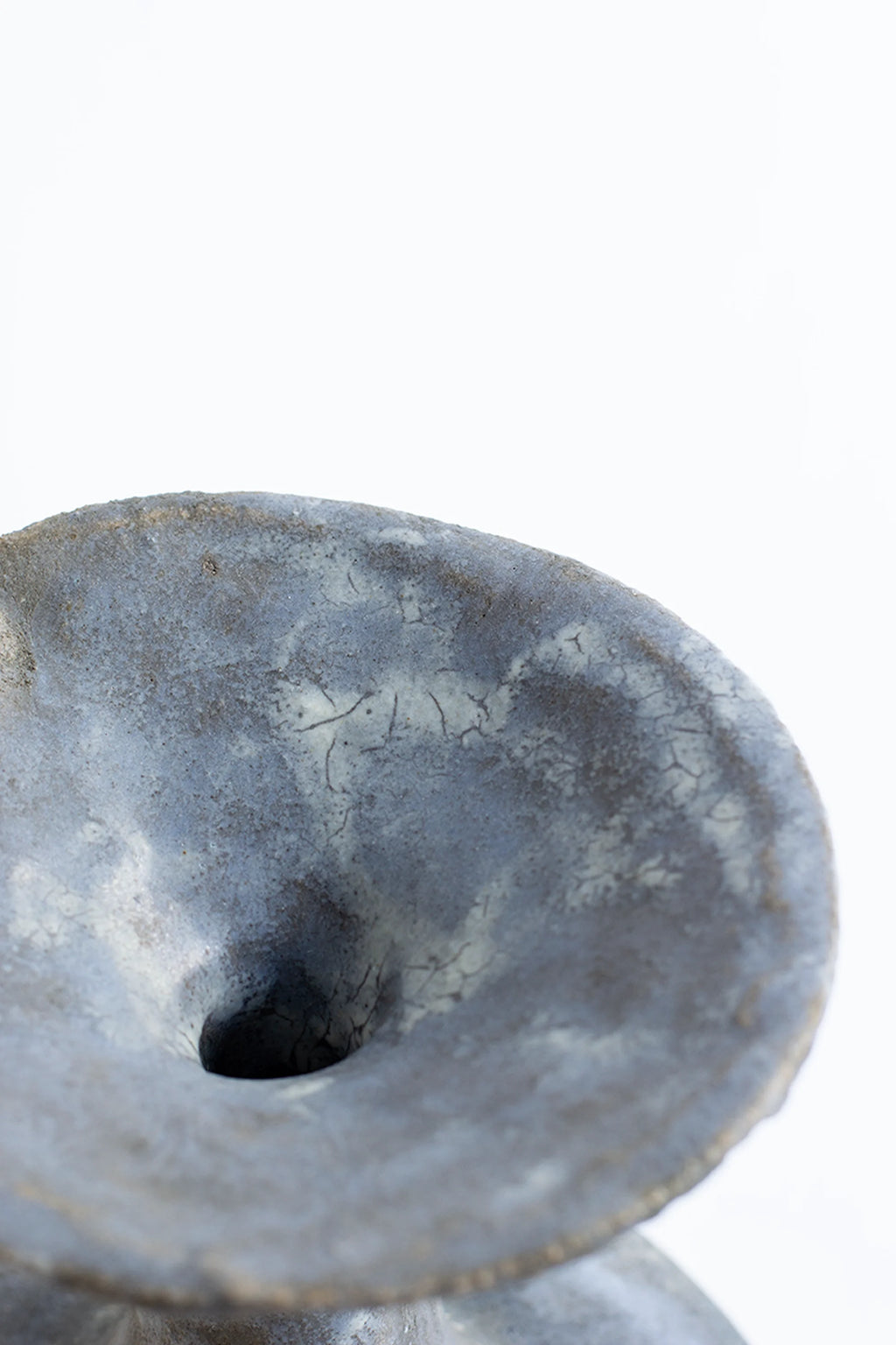 Canoa Lab Arq 015 Vase, a detailed top-down view showcasing the unique cracked glaze texture and dark, earthy tones of the ceramic, with a small central opening, on a white background.