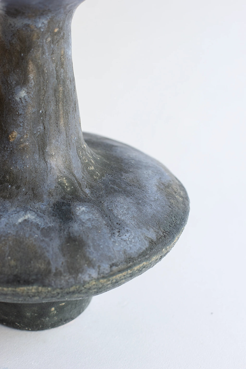 Canoa Lab Arq 015 Vase, a close-up of the dark, textured ceramic material with subtle blue-grey undertones and a rough, organic finish, displayed on a clean white background.