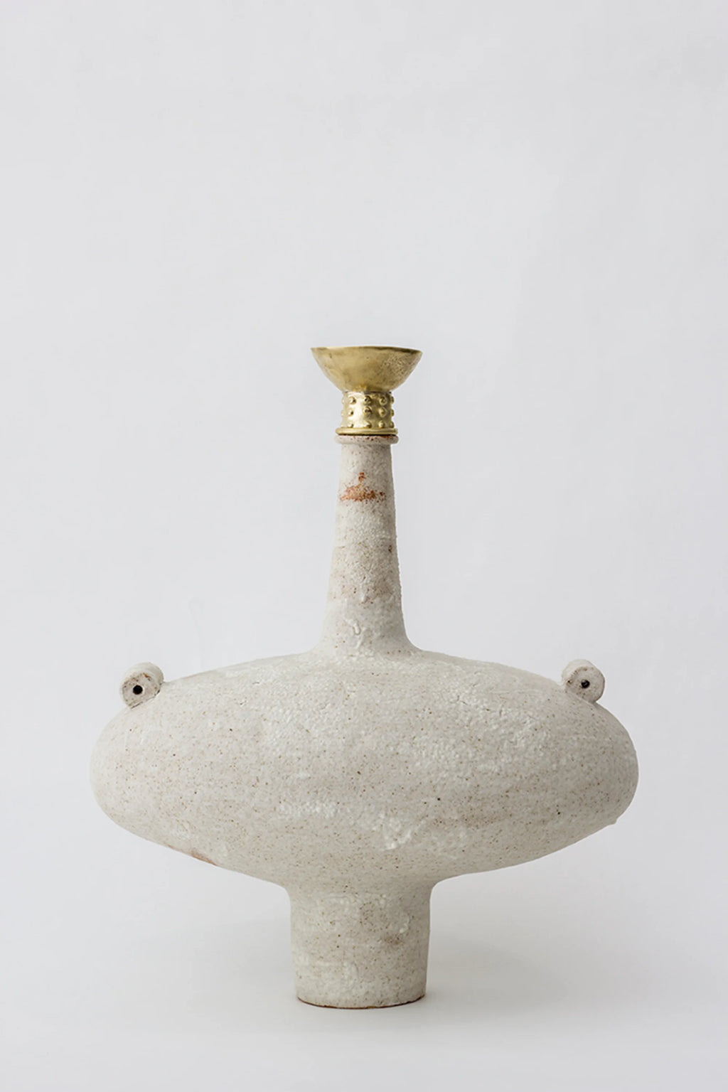 Canoa Lab Isolated n.13 Vase, a modern, sculptural, light beige ceramic vase with a wide, flattened body, a tall, slender neck, and a golden, cup-shaped top, displayed on a minimalist white background.