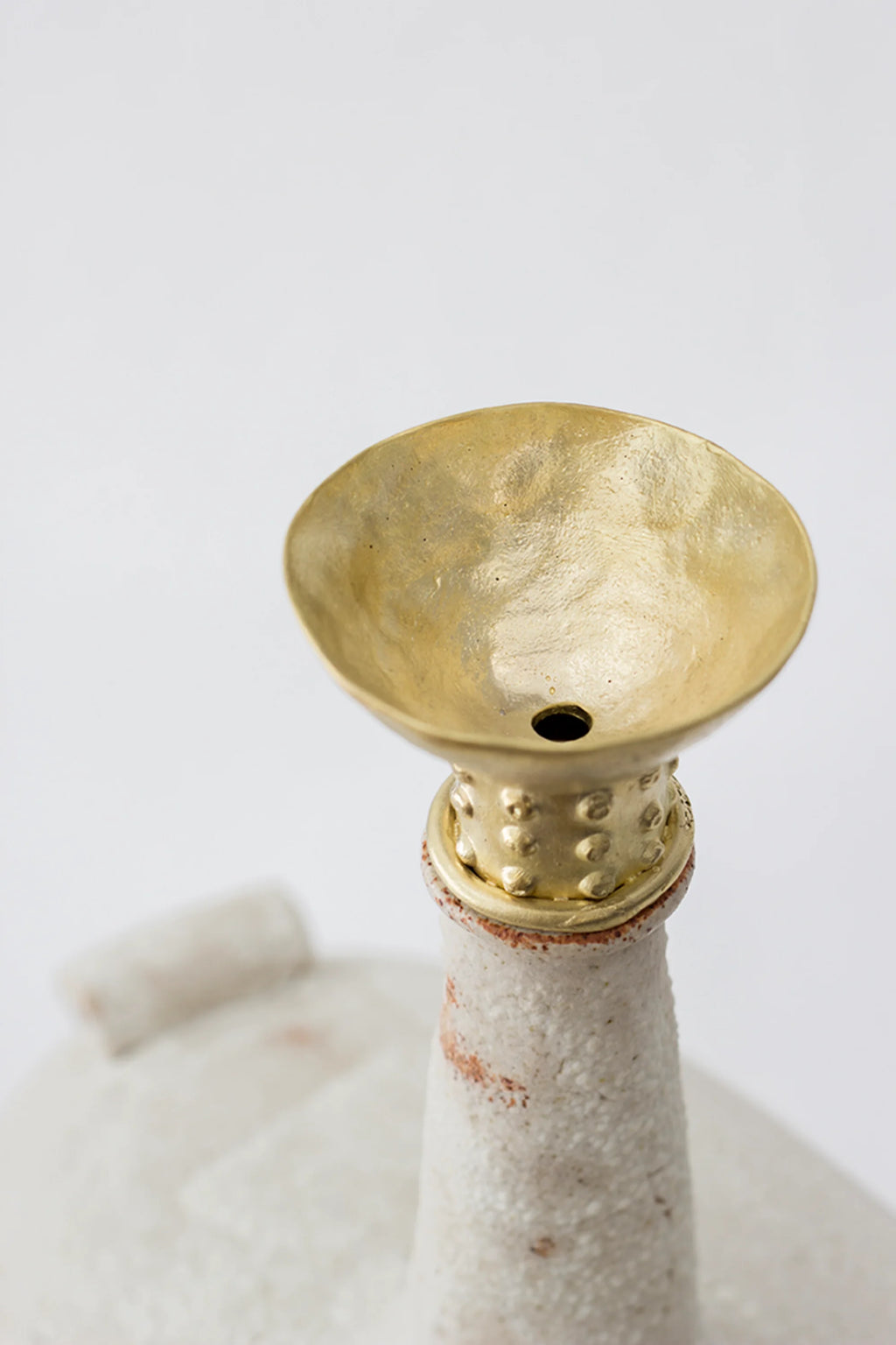 Canoa Lab Isolated n.13 Vase featuring a close-up of the elegant golden brass funnel-shaped top with a small central opening, atop a textured white ceramic neck, displayed on a clean white background.