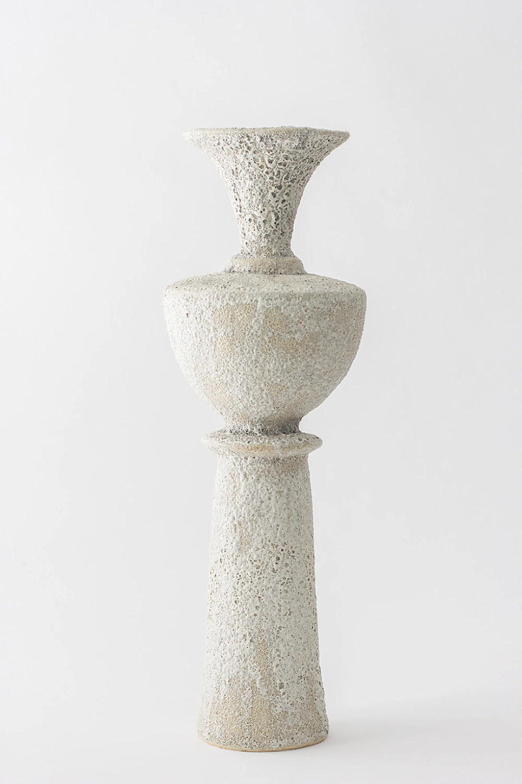 Canoa Lab Isolated n.20 Vase, a tall, elegant ceramic vase with a highly textured, porous off-white finish, featuring a flared top, a central bulbous section, and a slender base, on a white background.