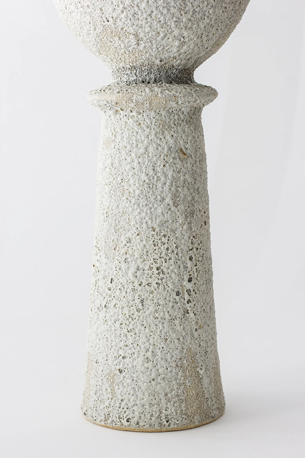 Canoa Lab Isolated n.20 Vase, a tall, elegant, and modern ceramic vase with a textured, porous white and grey finish, displayed on a clean white background. The unique design features a slender base and a wider, textured top.