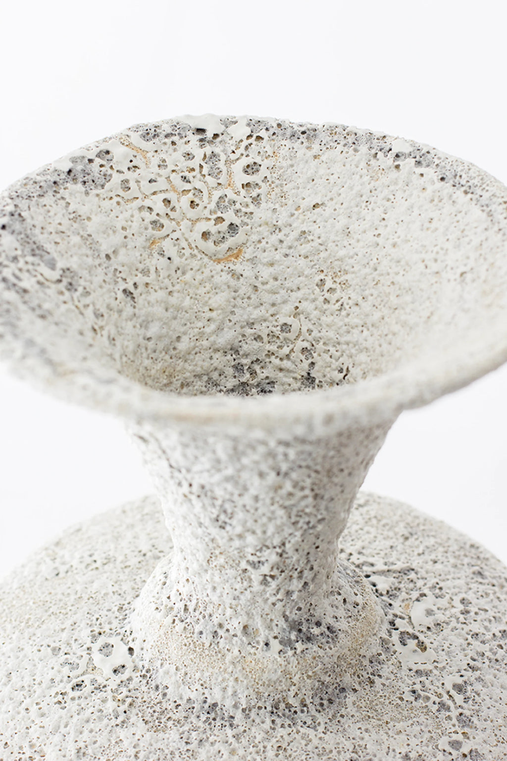 Canoa Lab Isolated n.20 Vase, a close-up of the elegant ceramic vase's textured opening, showcasing its porous white and grey finish with subtle golden undertones, displayed on a clean white background.