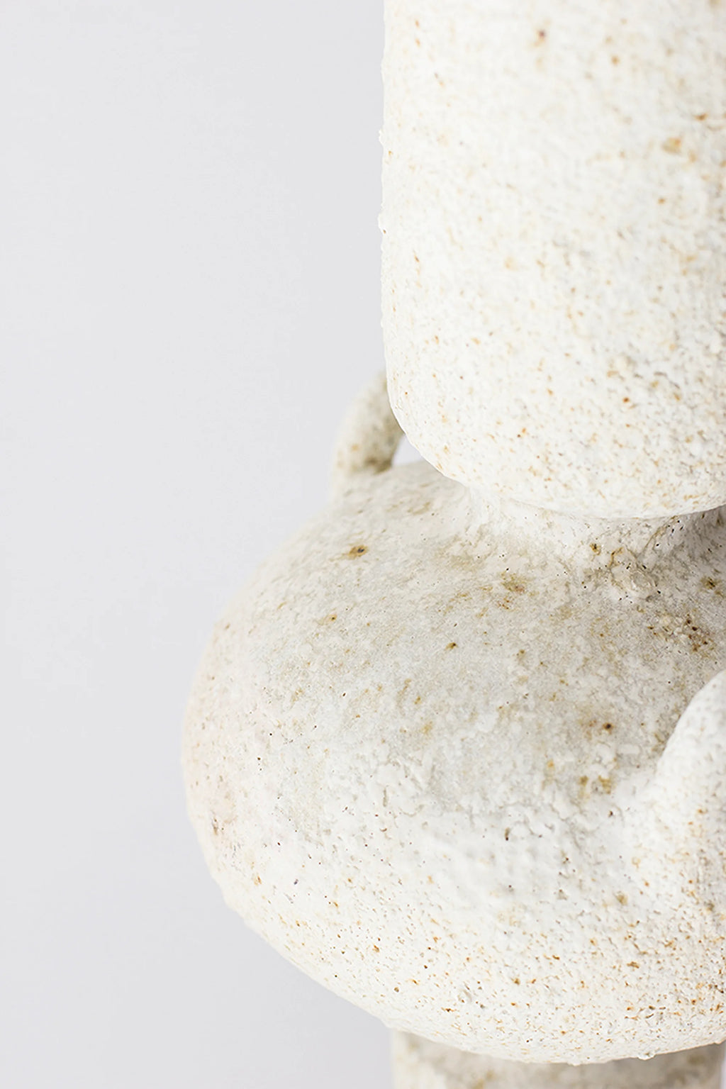 Canoa Lab Isolated n.23 Vase, a cream-colored handcrafted ceramic vase with an intensely porous and textured volcanic finish, showcasing warm off-white and subtle brown speckles on its organic, bulbous form. This unique stoneware art piece is perfect for wabi-sabi shelf styling or adding a rustic minimalist accent to contemporary living rooms.