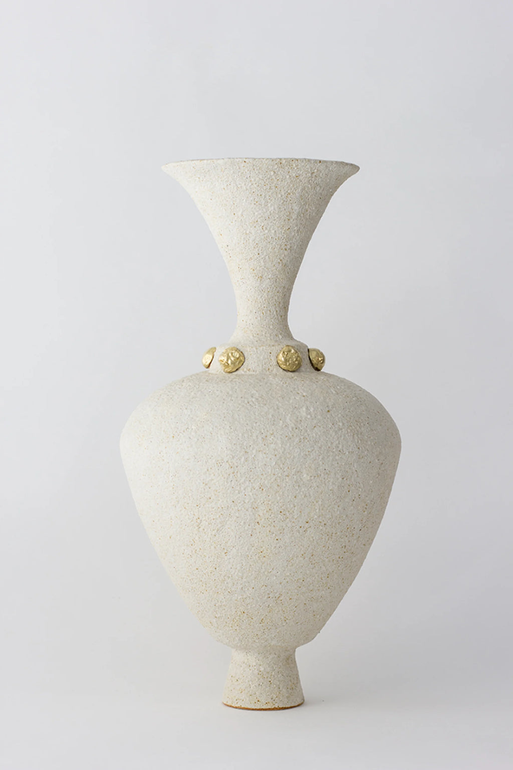 Canoa Lab Isolated n.24 Vase, an elegant, tall ceramic vase with a flared neck, bulbous body, and a textured off-white finish, adorned with golden accents around the neck, on a white background.