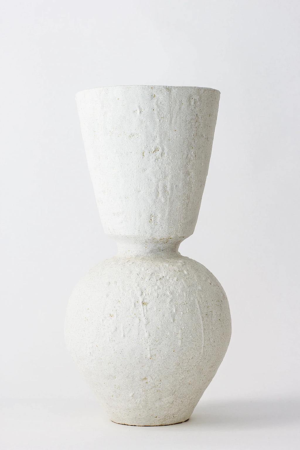 Canoa Lab Isolated n.26 Vase, a striking modern ceramic vase with a unique hourglass silhouette, featuring a textured, off-white finish, displayed prominently against a bright white background.