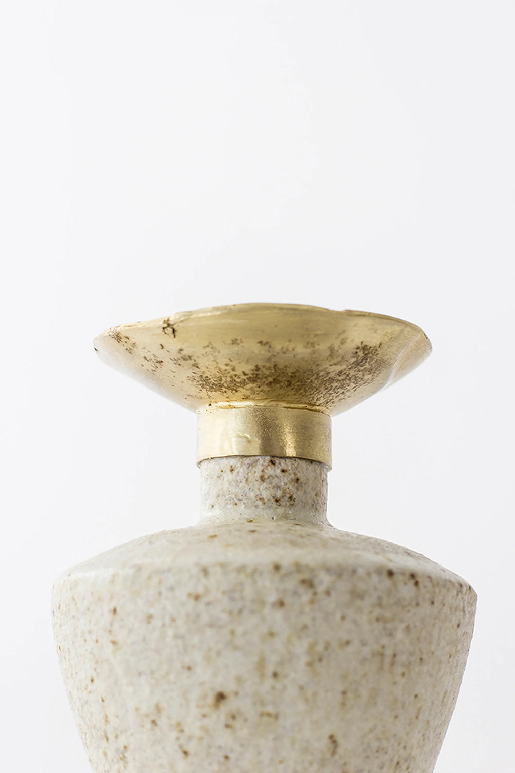 Canoa Lab Isolated n.6 Vase, a detailed view of the brass top and its connection to the speckled off-white ceramic body, highlighting the unique texture and craftsmanship.