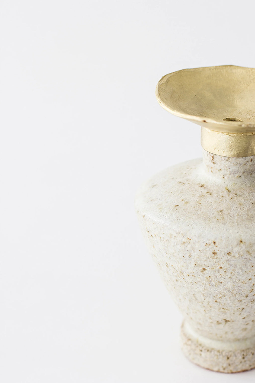 Canoa Lab Isolated n.6 Vase, a side view showcasing the unique silhouette of the speckled off-white ceramic body and the elegant, textured brass top, on a white background.