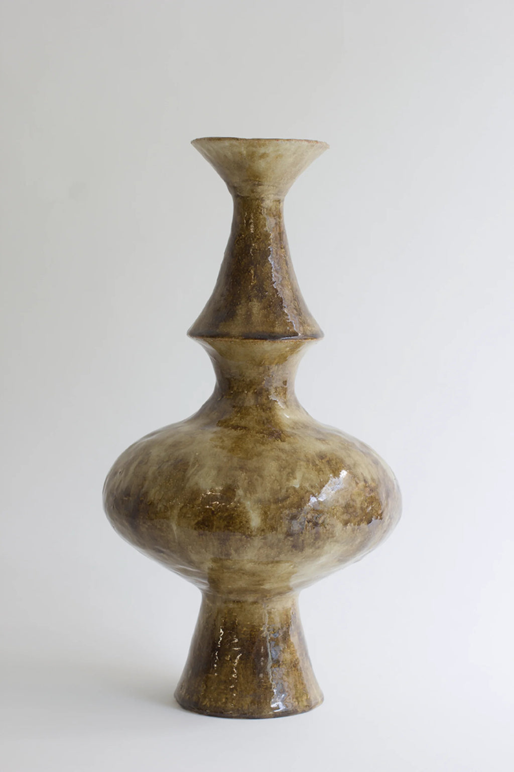 Canoa Lab Isolated n.28 Vase, a tall, elegant ceramic vase with a unique, multi-tiered silhouette and a glossy, mottled brown and beige glaze, displayed on a pristine white background.