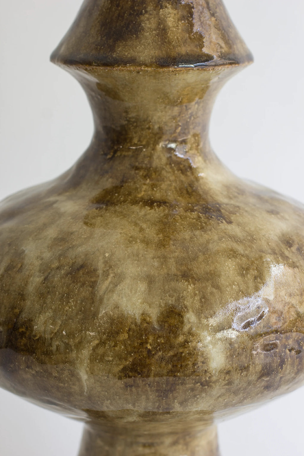 Canoa Lab Isolated n.28 Vase, a close-up of the vase's mid-section, showcasing its rounded, bulbous body and the rich, glossy, mottled brown and beige ceramic texture, displayed on a white background.