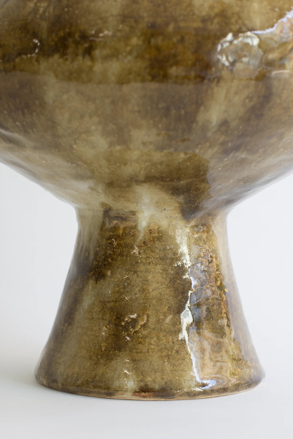Canoa Lab Isolated n.28 Vase, a close-up of the vase's flared base, highlighting the glossy, textured brown and beige ceramic material and its sturdy, elegant design, displayed on a white background.