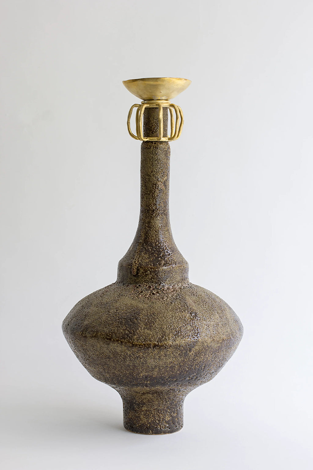 Canoa Lab Isolated n.29 Vase, a striking, tall, dark bronze-colored ceramic vase with a textured body, a slender neck, and an ornate golden cage-like top, on a white background.