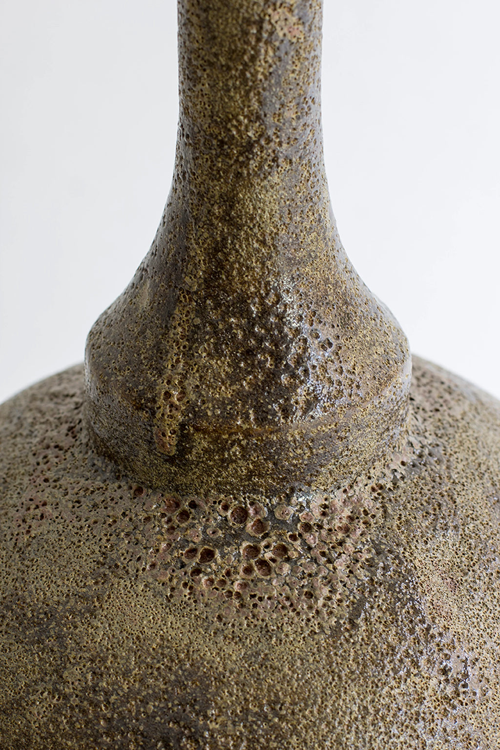 Canoa Lab Isolated n.29 Vase, a close-up of the vase's textured, earthy brown and dark gold surface, showcasing its unique, organic, and porous ceramic material, displayed on a clean white background.