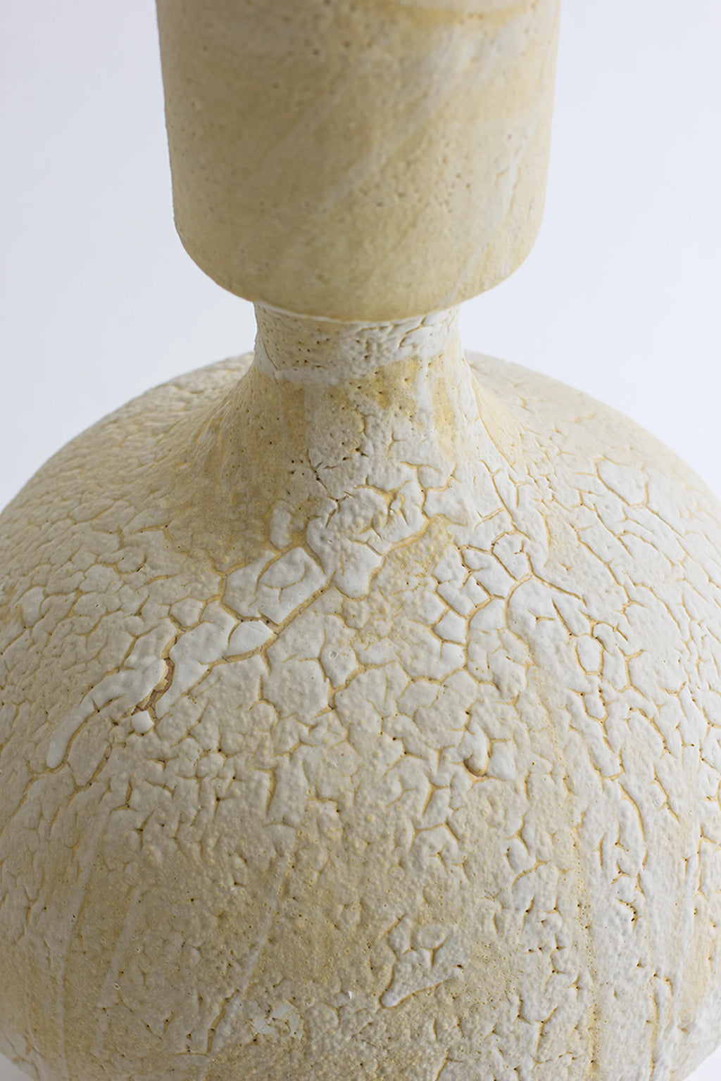 Canoa Lab Isolated n.30 Vase, a handcrafted ceramic vase in a natural cream and off-white finish, featuring a distinct cracked, porous volcanic texture and an organic globular shape with a slender.