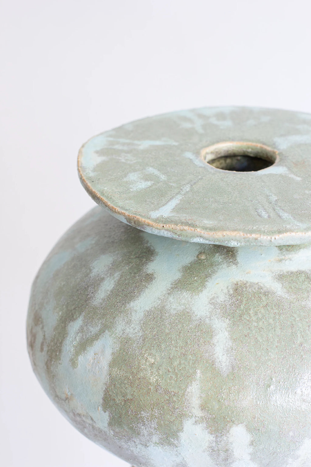 Canoa Lab Isolated n.33 Vase, a close-up of the top showing the flat, circular opening and the textured, mottled light blue and green glaze, highlighting the artisanal finish.