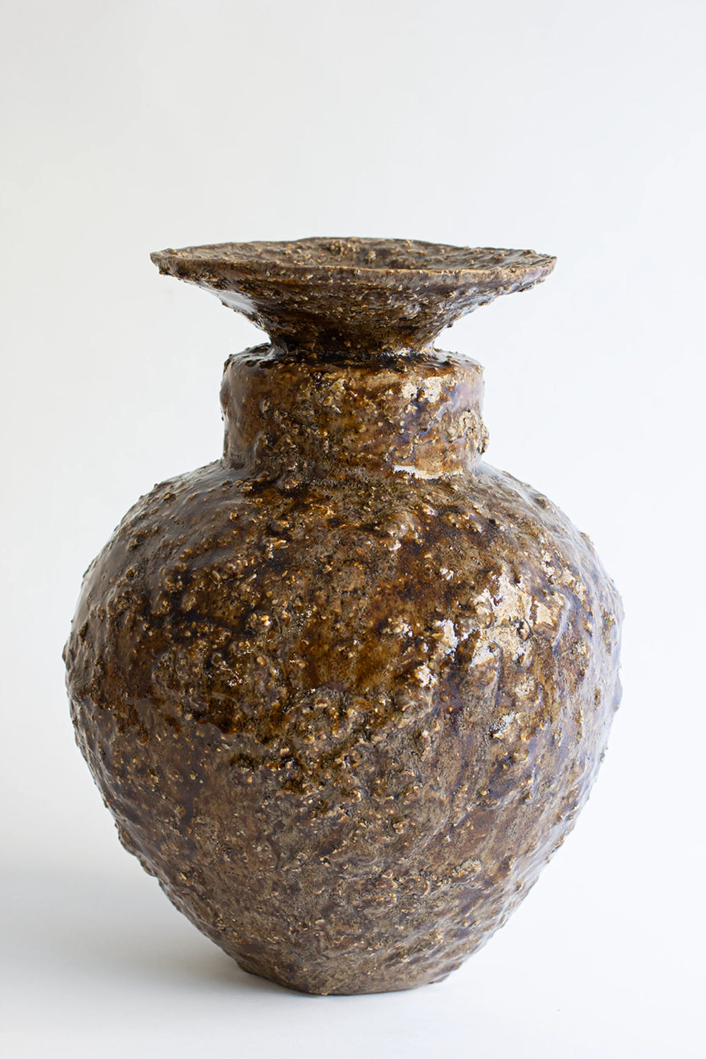 Canoa Lab Isolated n.34 Vase, a rustic, dark brown ceramic vase with a textured, organic surface and a wide, flat top, exuding an earthy, handcrafted aesthetic on a white background.