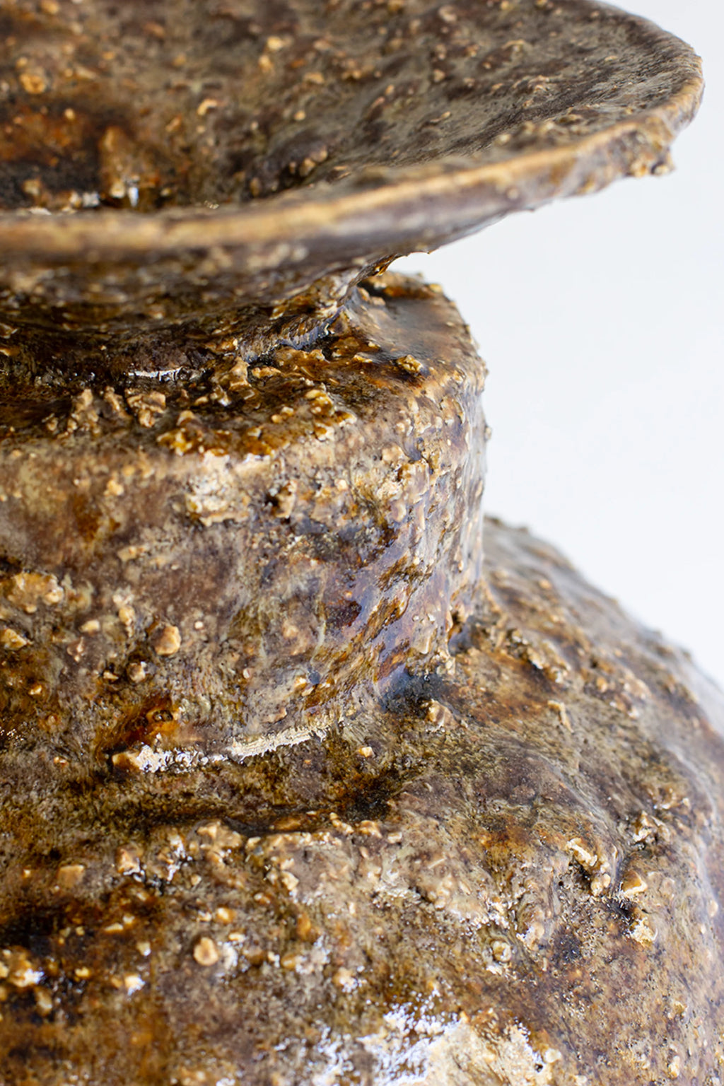 Canoa Lab Isolated n.34 Vase, a detailed view of the neck and shoulder, showcasing the thick, textured dark brown glaze with visible bumps and a natural, rugged appearance.