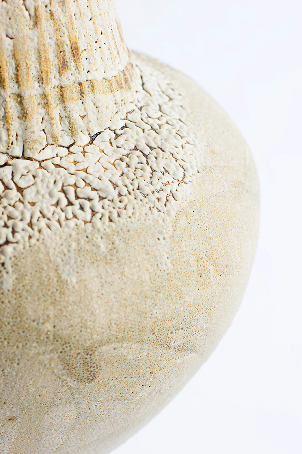 Canoa Lab Isolated n.35 Vase, a detailed close-up of the vase's textured, off-white ceramic surface, revealing intricate crackle patterns and subtle variations in its organic, handcrafted material, on a white background.