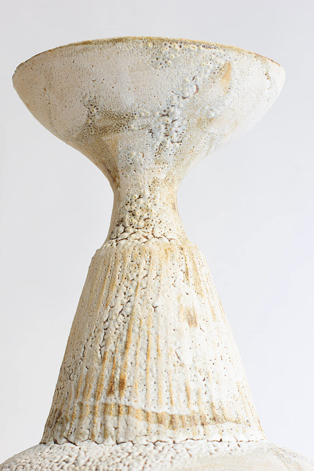 Canoa Lab Isolated n.35 Vase, a close-up of the vase's upper section, showcasing its flared, textured rim and the unique, ribbed, and crackled off-white ceramic finish, exuding a rustic elegance on a white background.