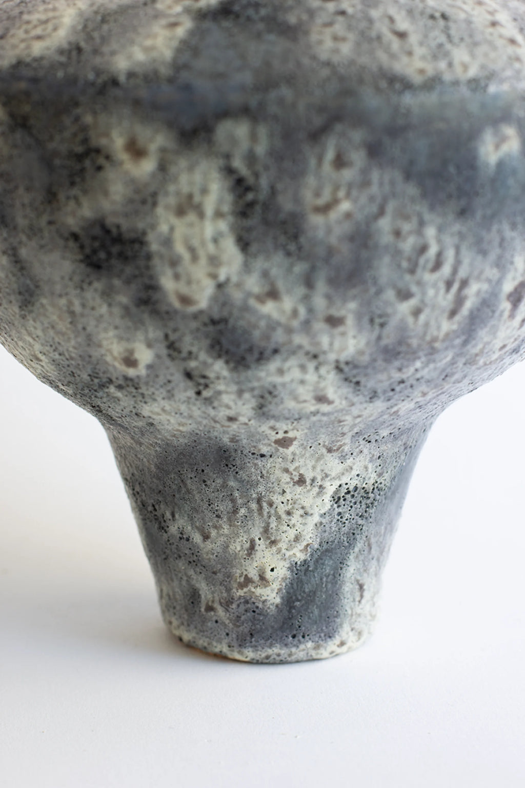 Canoa Lab Lydion Gecko Vase, showcasing the intricate, rough texture and speckled gray and white glaze of its base, with a subtle organic pattern, presented on a bright white surface.
