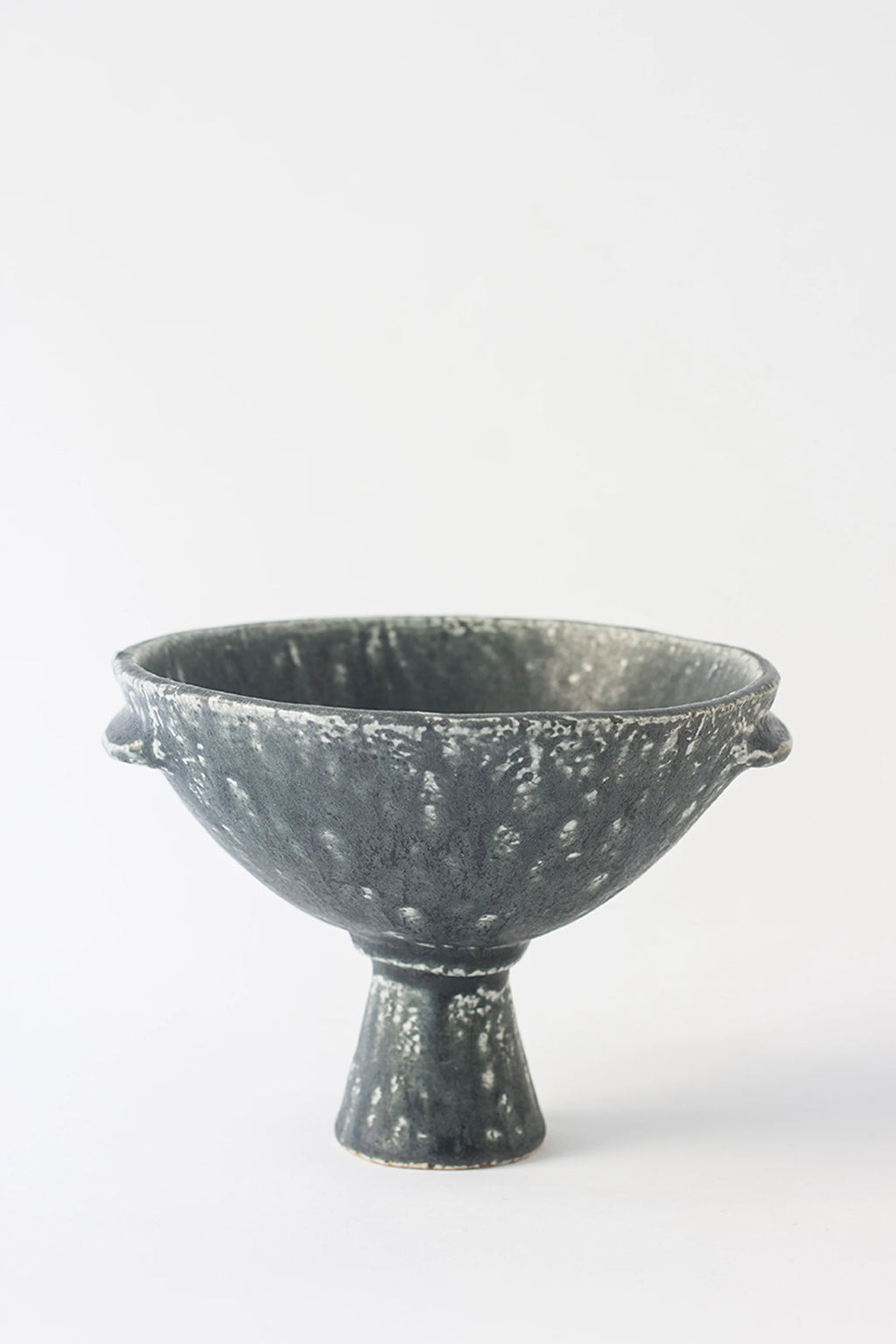 Canoa Lab Skypho Perla Negra Footed Bowl, a front view showcasing its deep, textured dark gray ceramic with a unique speckled pattern. The elegant, modern design features a sturdy footed base and subtle handles, displayed on a white background.
