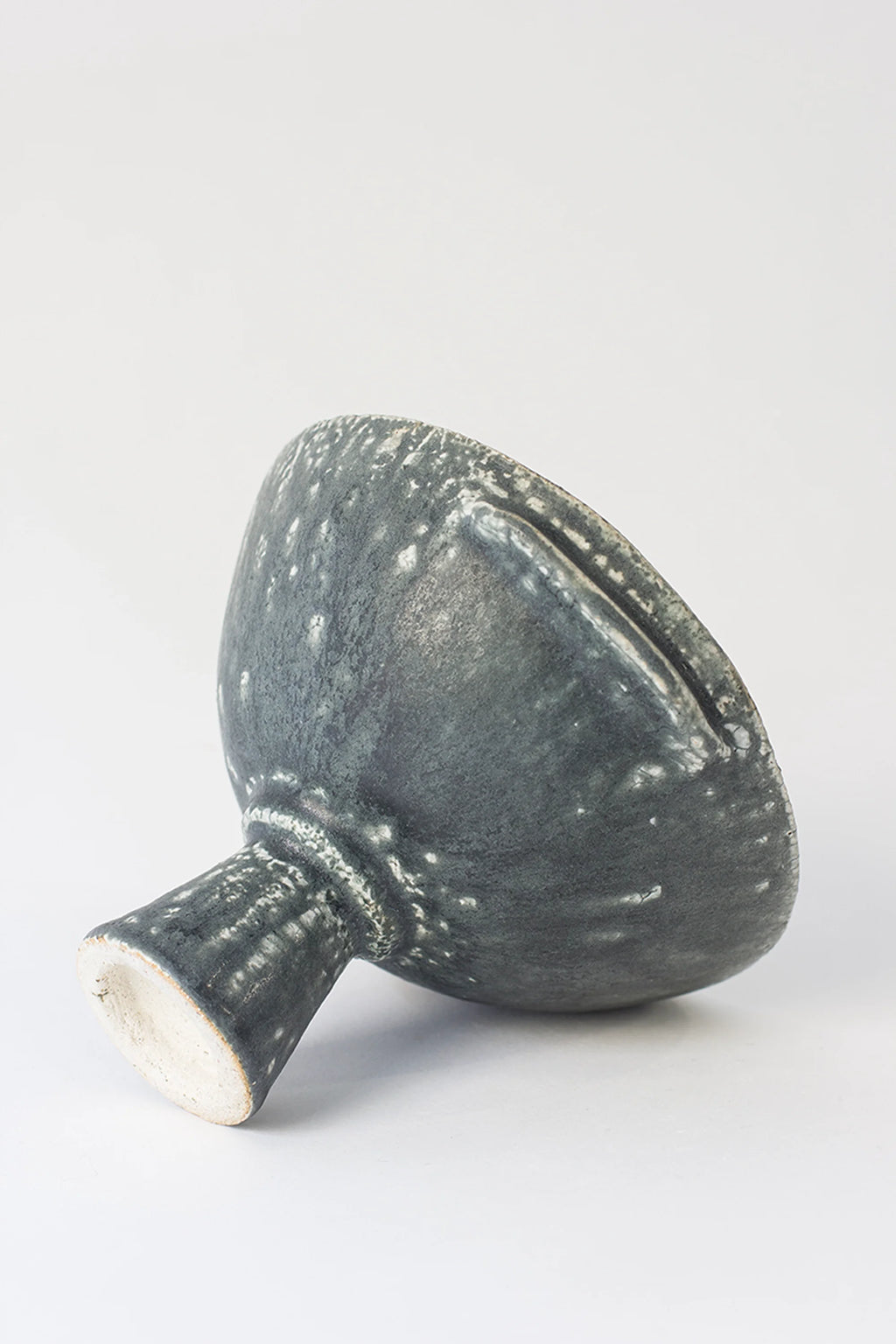 Canoa Lab Skypho Perla Negra Footed Bowl, an angled side view revealing the unique textured dark gray ceramic with prominent white speckles. The elegant, modern design features a sturdy footed base and subtle handles, displayed on a white background.