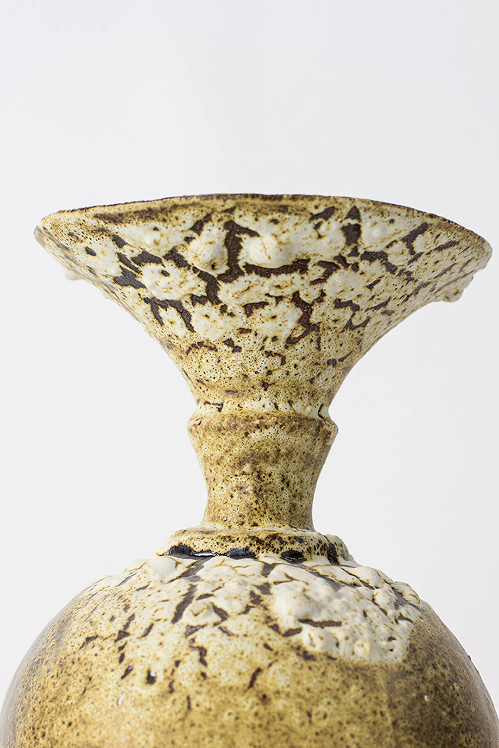 Canoa Lab Ánfora Limonita Vase, a close-up of the vase's elegant flared rim and neck, showcasing the intricate crackled limonita yellow and white glaze pattern, on a white background.