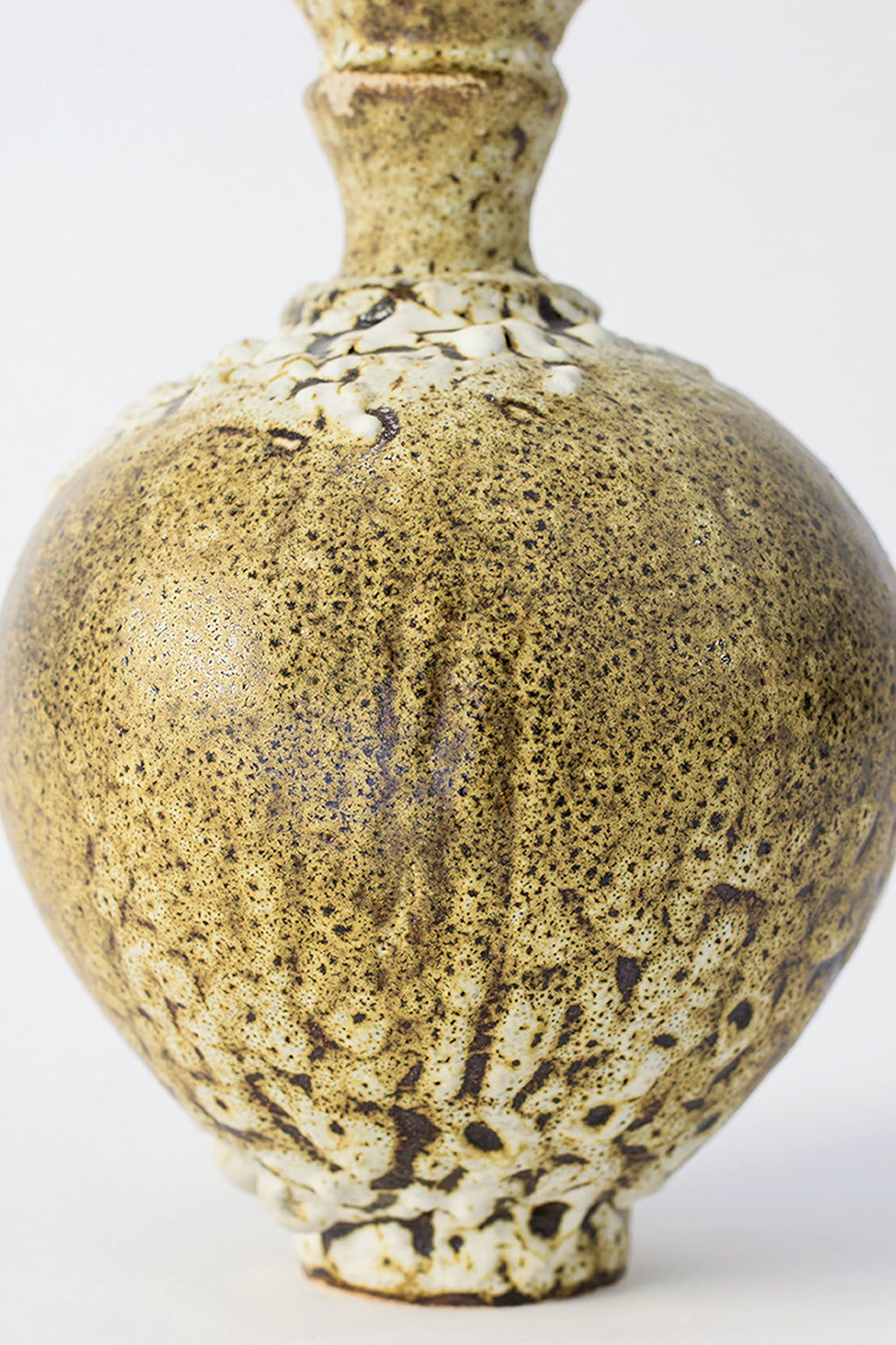 Canoa Lab Ánfora Limonita Vase, a detailed view of the vase's bulbous body, highlighting the rich, textured limonita yellow glaze with striking white crackle accents, on a white background.