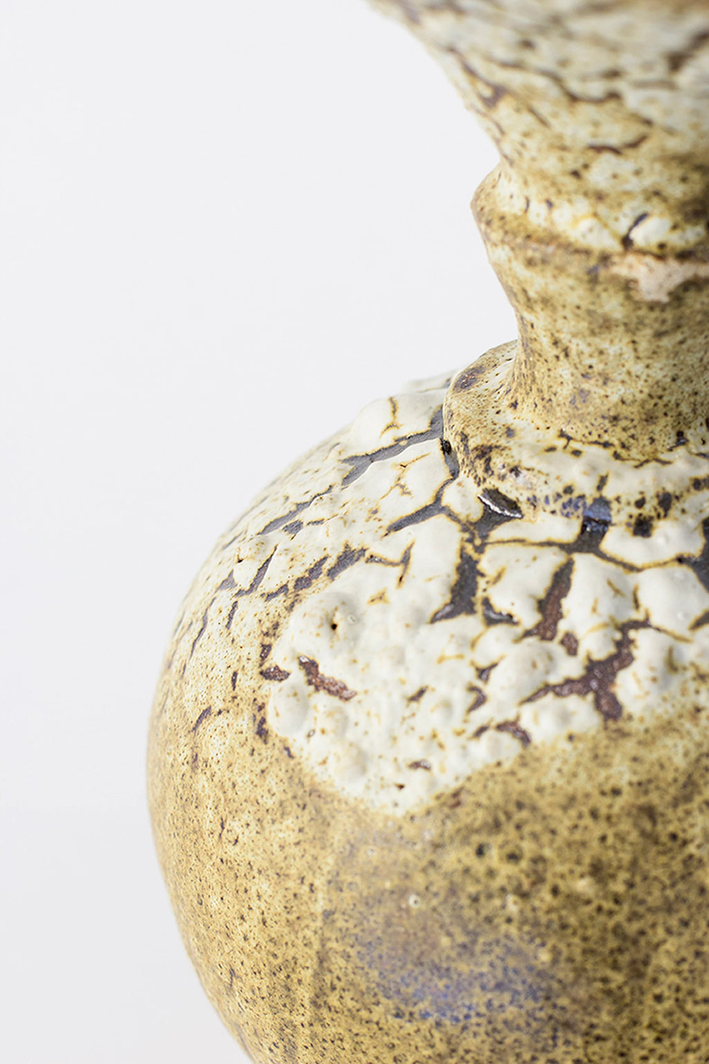 Canoa Lab Ánfora Limonita Vase, a side close-up revealing the beautiful transition of the limonita yellow glaze into the pronounced white crackle pattern on the vase's shoulder, on a white background.