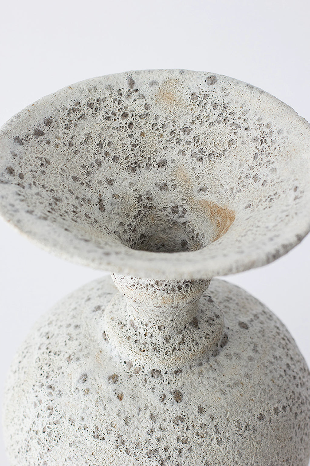 Canoa Lab Ánfora Vase, a close-up of the elegant, wide-mouthed top and neck, showcasing its unique textured, porous light gray ceramic material with subtle dark speckles, displayed on a clean white background.