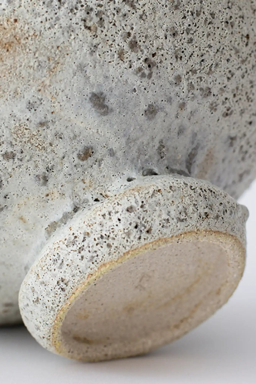 Canoa Lab Cálpide Vase, a handcrafted ceramic vase showcasing a unique porous volcanic texture in mottled grey, cream, and beige tones, crafted from artisanal unglazed stoneware.