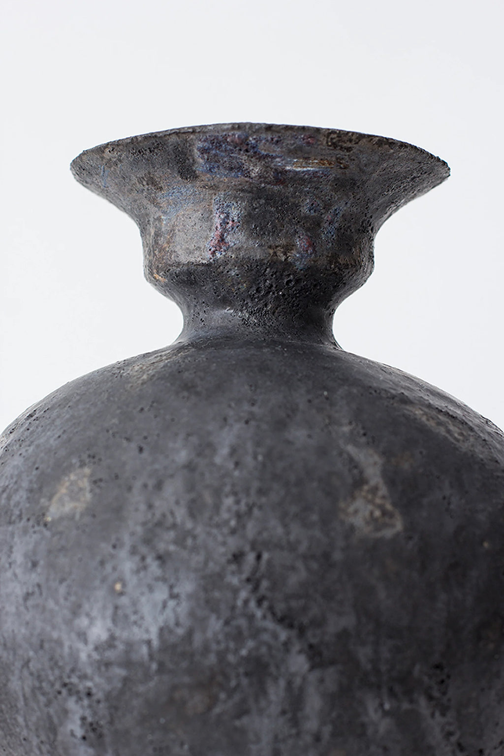 Canoa Lab Lekytho Vase, a close-up of the vase's neck and upper body, revealing the rich, dark charcoal ceramic with a textured, slightly iridescent finish, highlighting its unique artisanal craftsmanship.