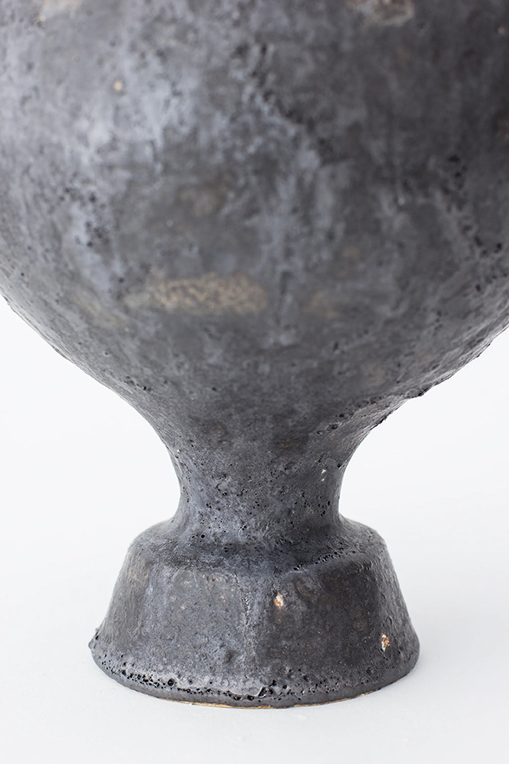 Canoa Lab Lekytho Vase, a dark grey handcrafted ceramic vase with a deeply textured, porous volcanic finish and an organic, amphora-inspired silhouette.