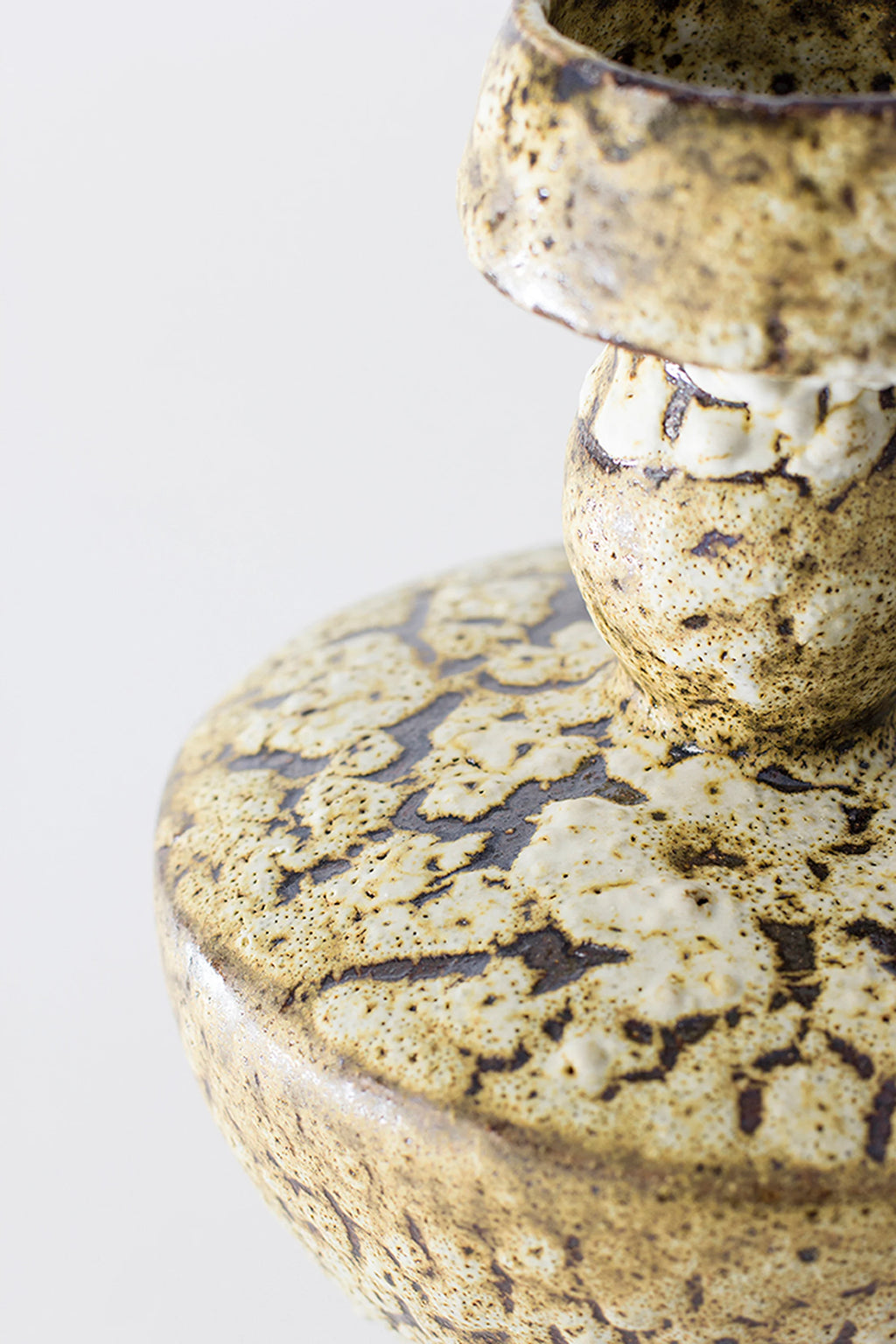 Canoa Lab Lydion Limonita Vase, a detailed close-up of the mid-section, highlighting the distinctive textured pattern and speckled brown-cream glaze, showcasing the artisanal quality on a white background.