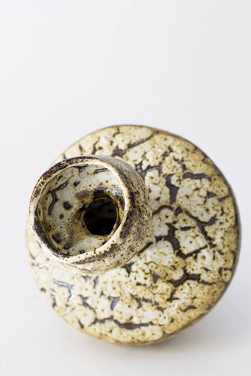 Canoa Lab Lydion Limonita Vase, a top-down view revealing the circular opening and the intricate, speckled brown and cream textured glaze across the entire surface, presented on a white background.