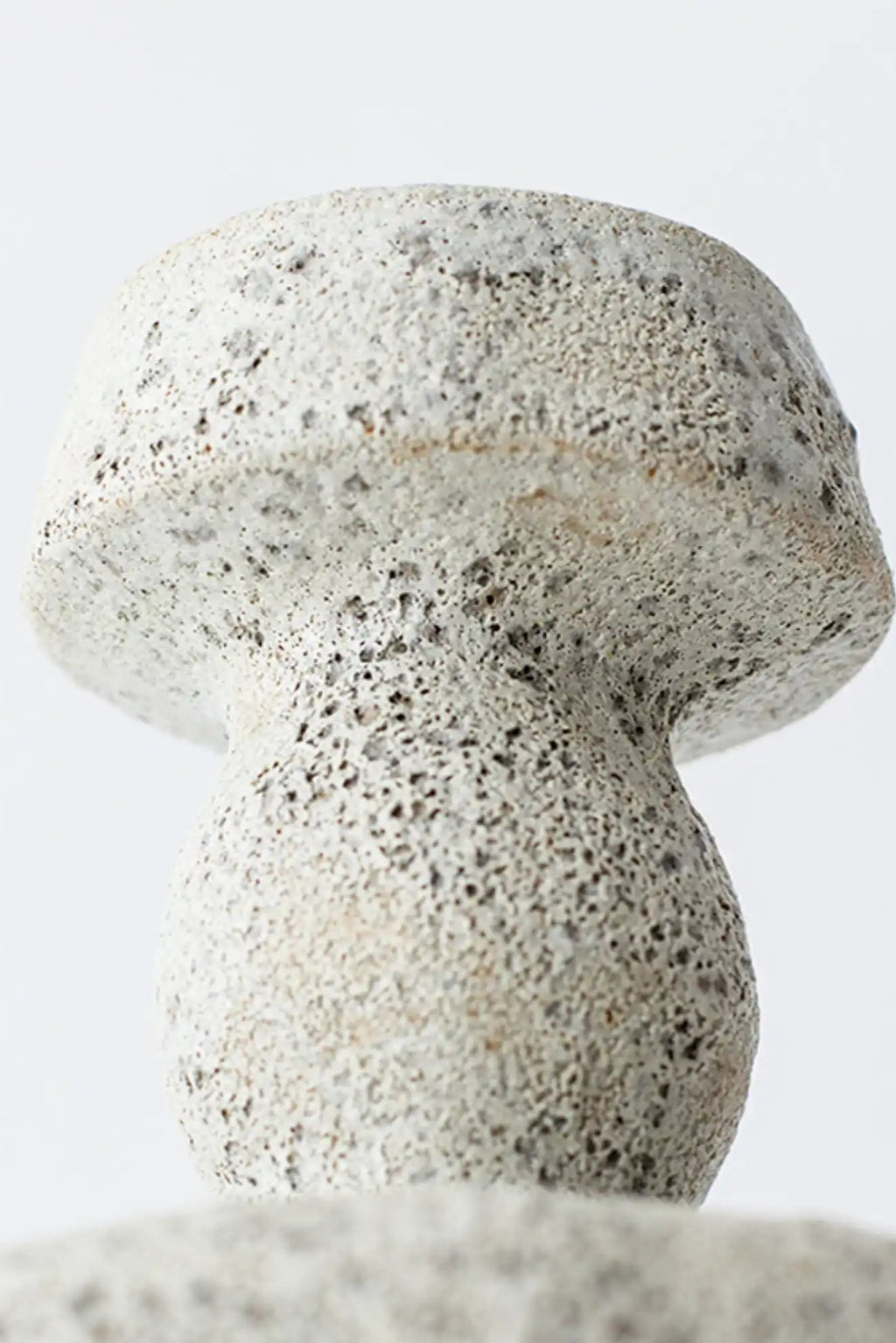 Canoa Lab Lydion Vase, a handcrafted grey ceramic vase featuring a distinctive porous volcanic texture and an organic mushroom-like silhouette, crafted from natural stoneware with dark speckles. This sculptural piece offers a rustic wabi-sabi aesthetic, perfect for modern minimalist shelf styling or as a unique accent in contemporary organic modern interiors.