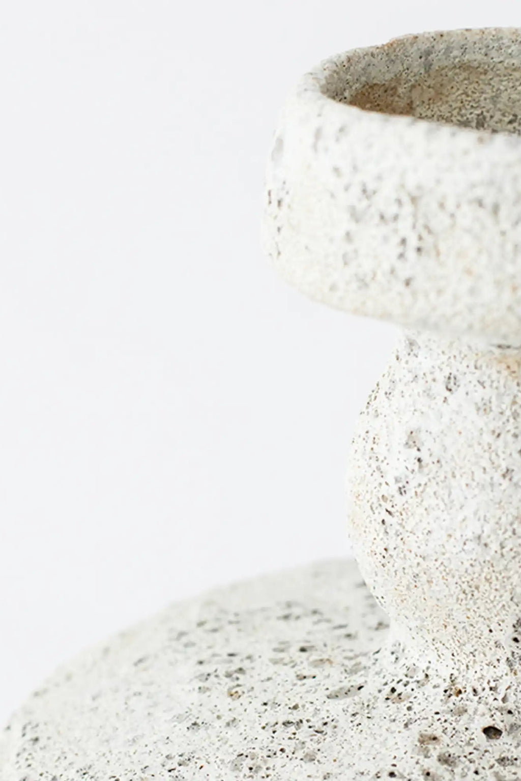 Canoa Lab Lydion Vase, a light grey handcrafted ceramic vase with a distinctive textured porous finish reminiscent of volcanic rock or natural pumice. This modern sculptural stoneware piece features an organic, wabi-sabi inspired silhouette with a subtle cream and speckled grey palette. Perfect for minimalist shelf styling or as a striking accent in organic modern and Brutalist-inspired interiors.