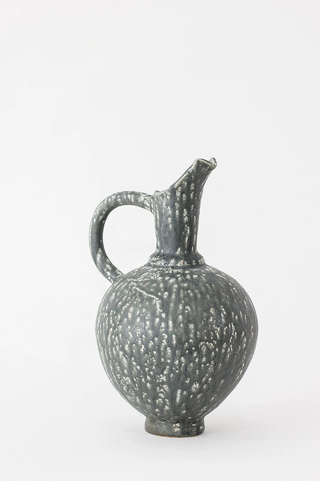 Canoa Lab Oinochoe Perla Negra Pitcher, a full view of the elegant, dark gray ceramic pitcher with a unique speckled white glaze pattern, featuring a classic handle and spout, displayed on a white background.