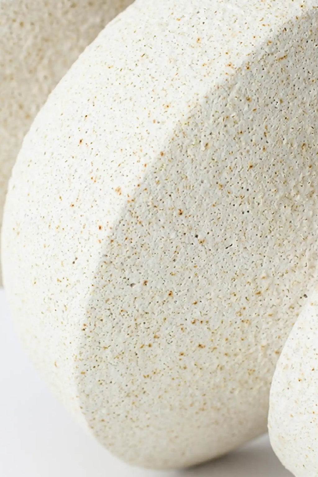 Canoa Lab Psychter Vase, a cream-colored handcrafted ceramic vase with a highly porous, textured volcanic finish and subtle geometric facets, crafted in artisanal stoneware with warm off-white and speckled brown tones. Perfect for organic modern shelf styling, minimalist interiors, or japandi living rooms.