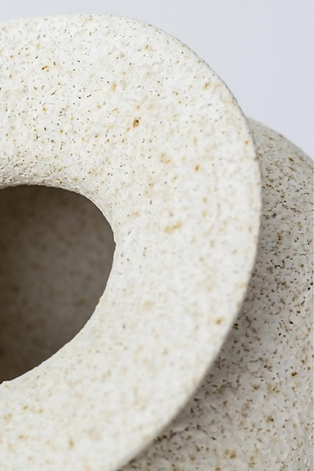 Canoa Lab Psychter Vase, a cream-colored handcrafted ceramic vase featuring a highly textured, porous volcanic finish with natural brown and tan speckles, showcasing a thick, rounded rim. This artisanal stoneware vase brings an organic modern aesthetic, perfect for rustic shelf styling or minimalist living room decor.