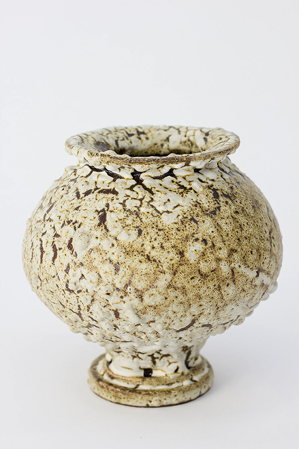 Canoa Lab Stamnos Limonita Vase, a rustic, handcrafted ceramic vase with a rounded body and a subtly ruffled rim. It features a distinctive crackled white and brown glaze, creating an earthy, organic aesthetic, displayed on a white background.