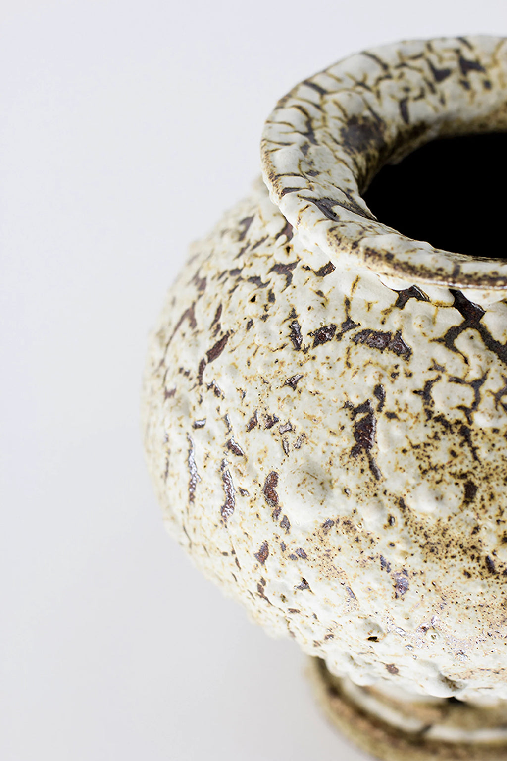 Canoa Lab Stamnos Limonita Vase, a detailed side view highlighting the vase's rounded form and the textured, crackled white and brown glaze. The organic, earthy pattern gives it a distinct, handcrafted appeal, displayed on a white background.
